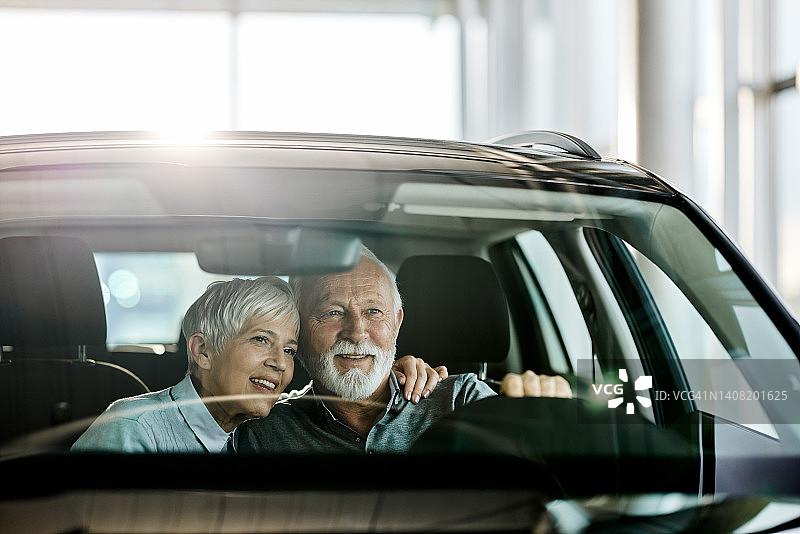 快乐的老年夫妇在汽车展厅里图片素材
