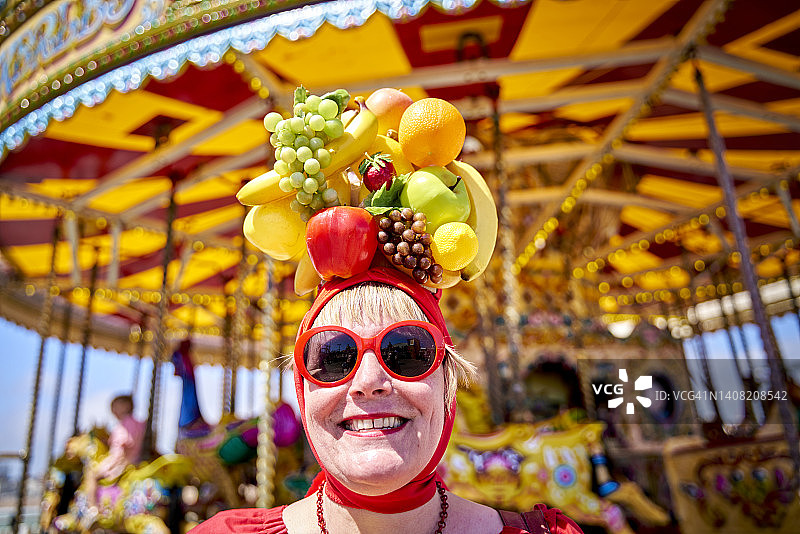 头顶水果面带微笑看向镜头的女人图片素材