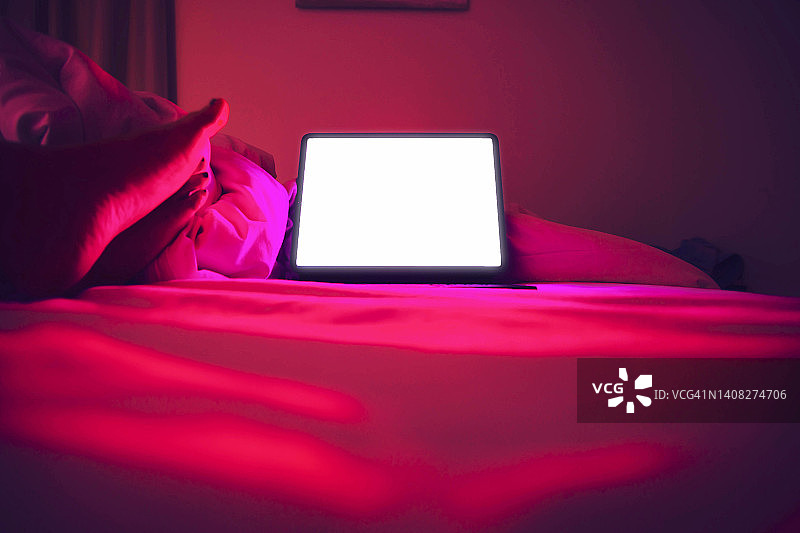 在家用笔记本电脑在床上观看流媒体剧集图片素材