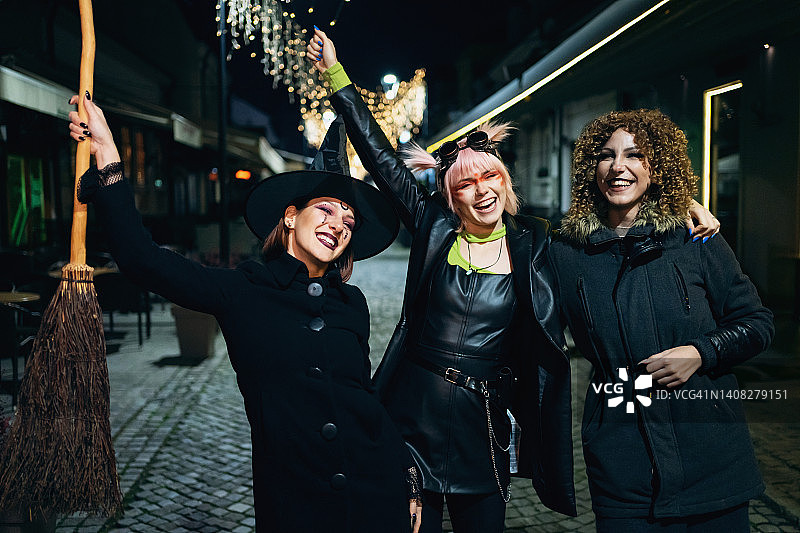 三个年轻女人穿着服装去参加万圣节派对图片素材