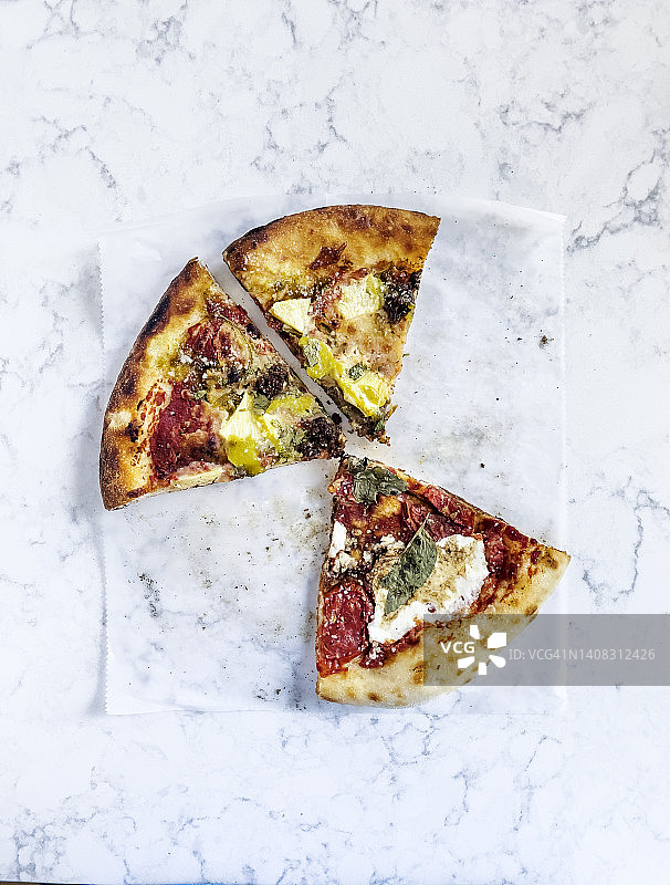 白色背景下烘焙纸上的剩披萨切片图片素材