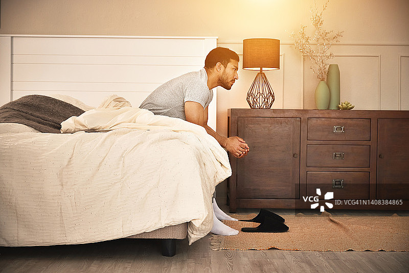 一个悲伤、孤独的男人早上醒来，患有失眠症，处理着因疲劳和倦怠引起的精神健康问题，情绪低落的年轻人感到沮丧和担忧图片素材