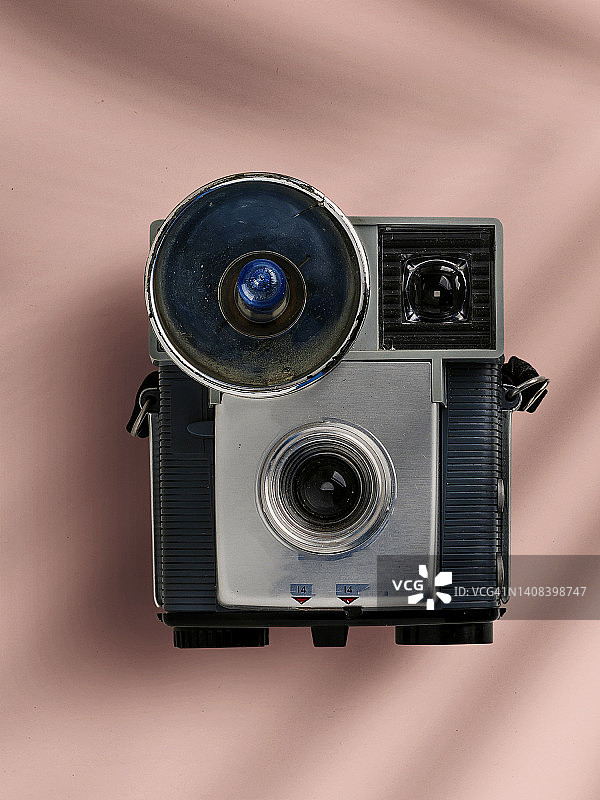 粉色表面上投下阴影的复古照相相机俯视图图片素材