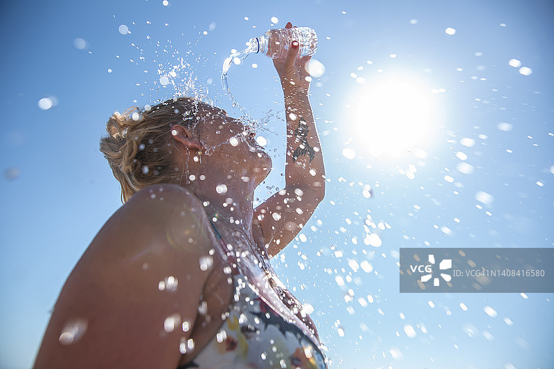 年轻女子在夏季用冷水降温图片素材