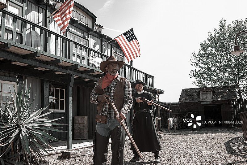 帅气黑人牛仔与牧师在狂野西部背景中图片素材