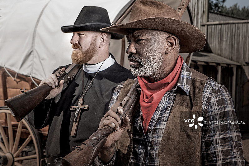 帅气黑人牛仔与牧师在狂野西部背景中图片素材