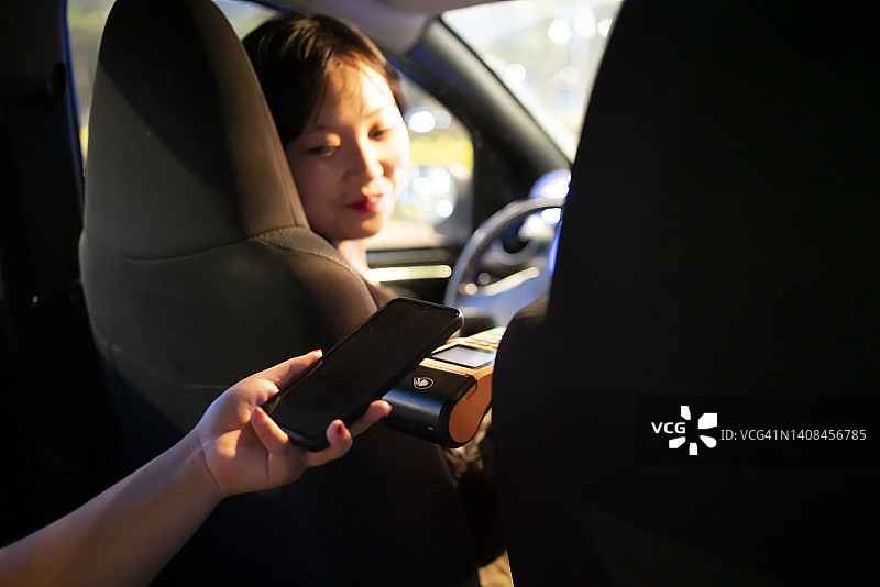 乘客在车内用手机支付车费图片素材