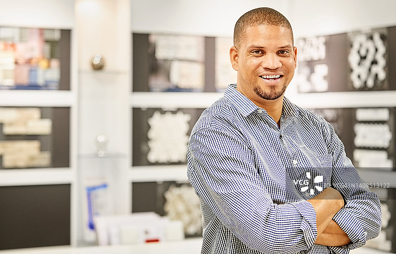 在瓷砖店工作的快乐销售员肖像图片素材