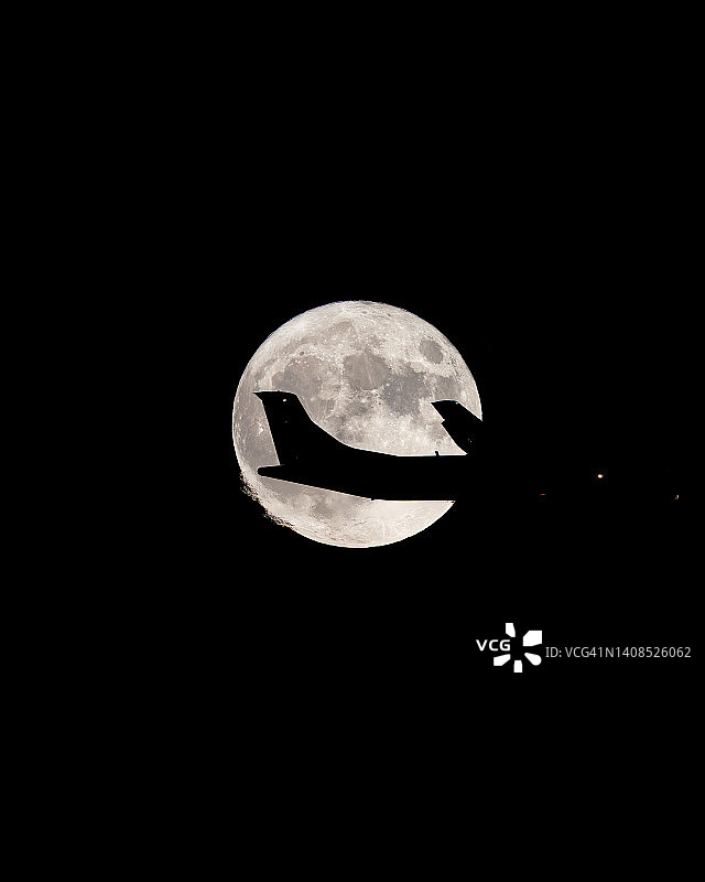 ATR 72飞机飞过满月，满月前的飞机剪影图片素材