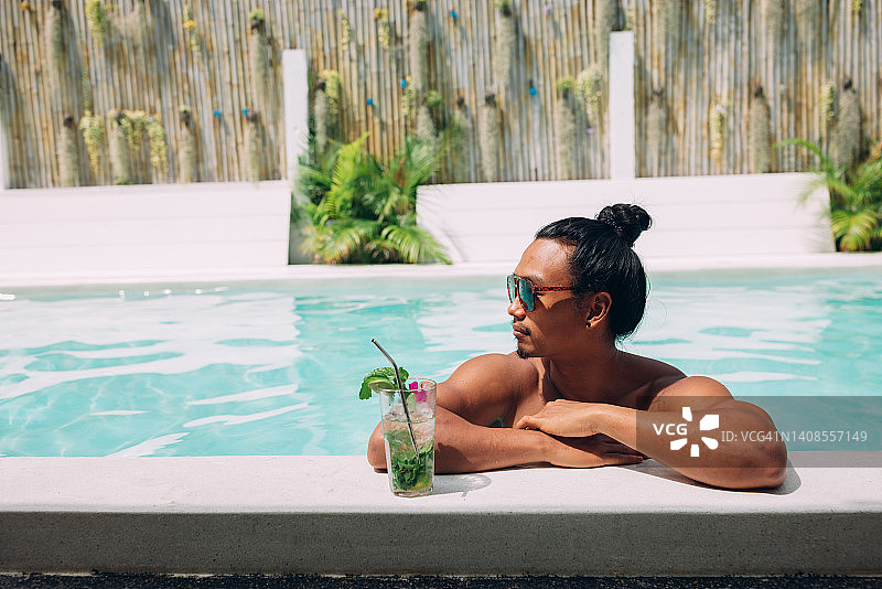 亚洲男人在假期享受泳池图片素材