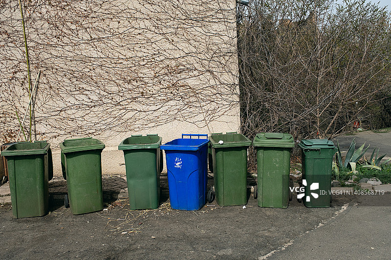 一排排列在街上的塑料垃圾箱或垃圾桶，用于移动和运输的带轮罐，环保、可持续生活方式理念，垃圾回收图片素材