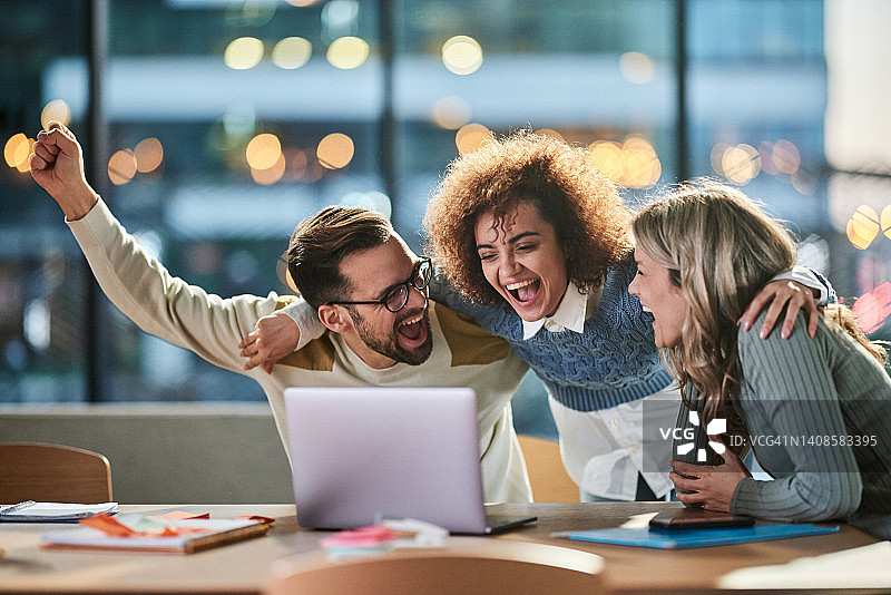 在办公室用笔记本电脑工作的快乐创意团队图片素材