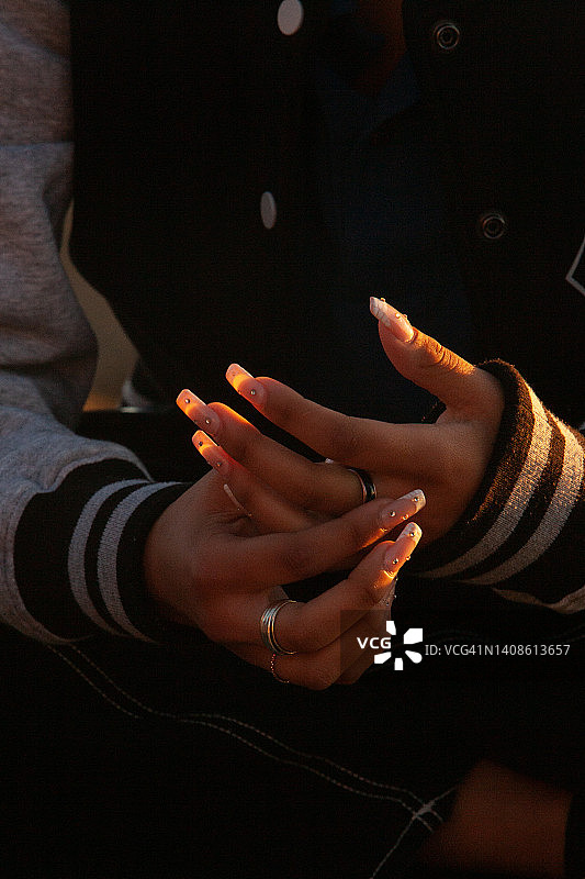 佩戴银戒指和金属戒指及长指甲的精美双手特写图片素材