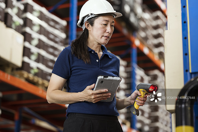 使用条形码解决方案进行物流供应链的接收检验。女性仓库管理员使用条形码读取器扫描包裹，以匹配库存管理软件中的数字图片素材