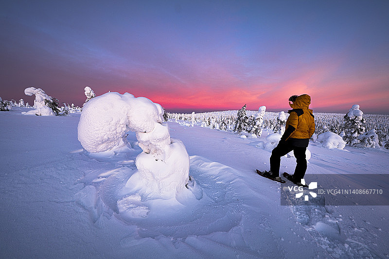 穿着雪鞋欣赏拉普兰冰雕的徒步旅行者图片素材