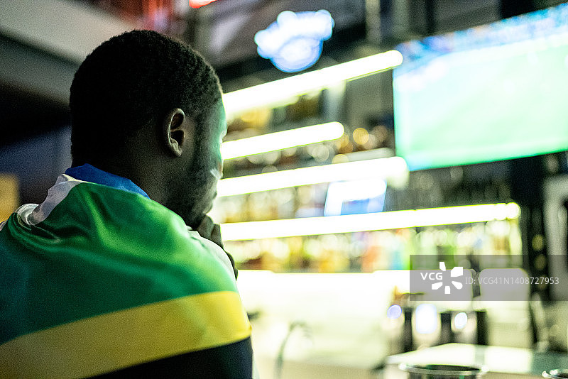 年轻男人在酒吧观看运动队比赛图片素材