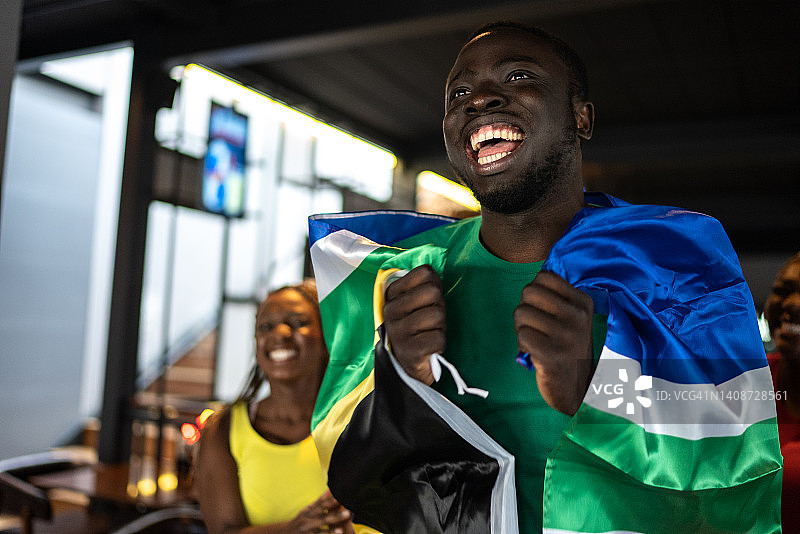 在酒吧观看比赛并庆祝的体育迷朋友图片素材