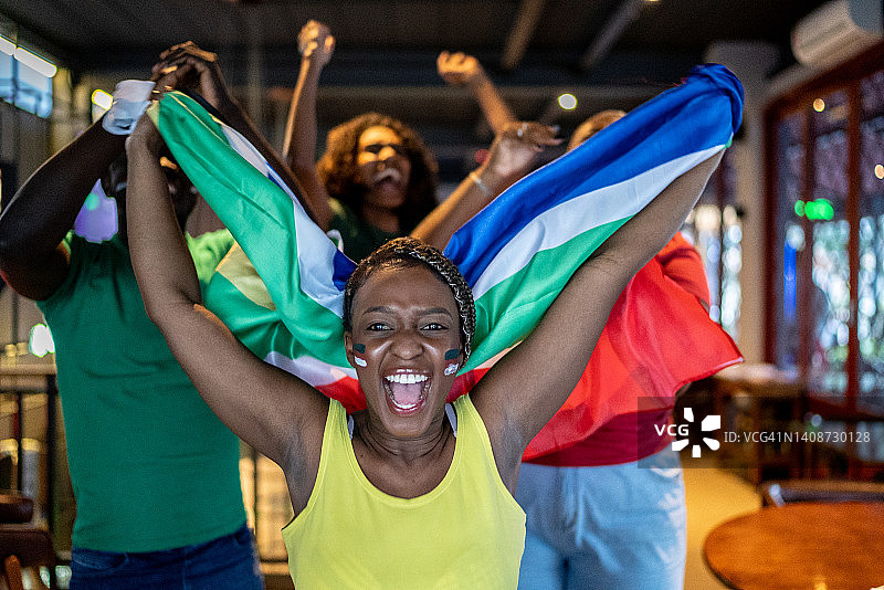 在酒吧观看比赛并庆祝的体育迷朋友图片素材