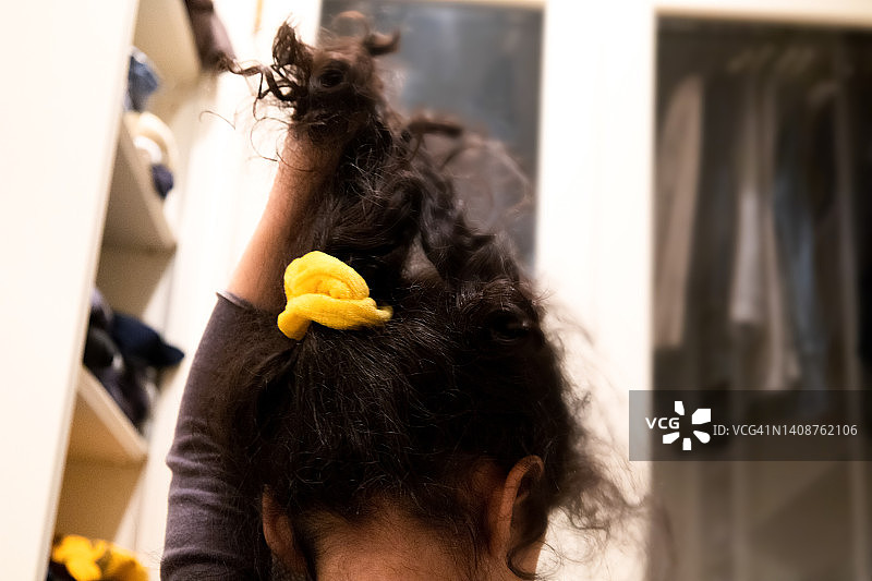 在父亲衣帽间玩耍的年轻女孩图片素材