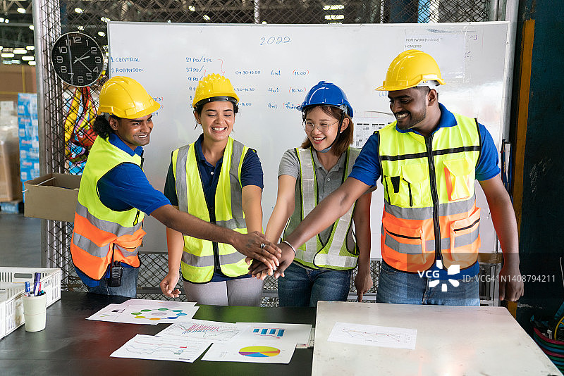 仓库工厂中为团队合作而携手的一组工程师和工人图片素材