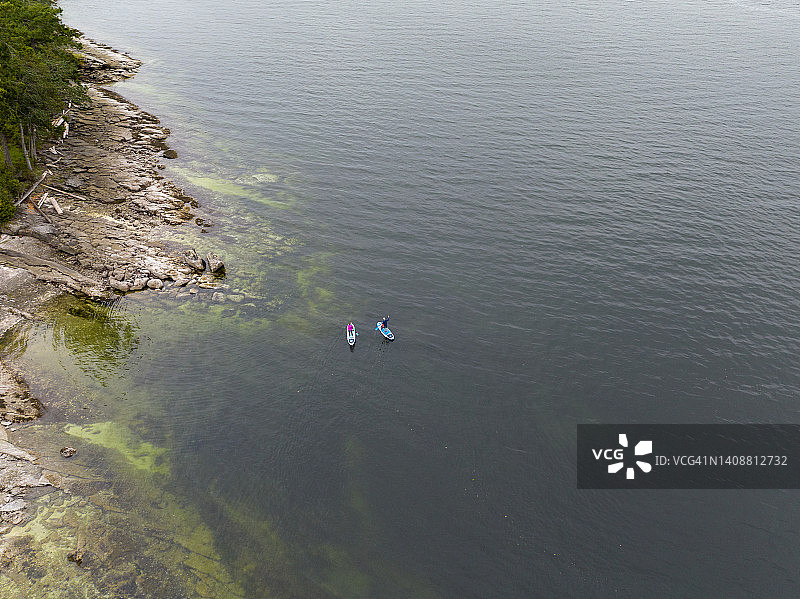 情侣与孩子在海岸线一起桨板冲浪图片素材