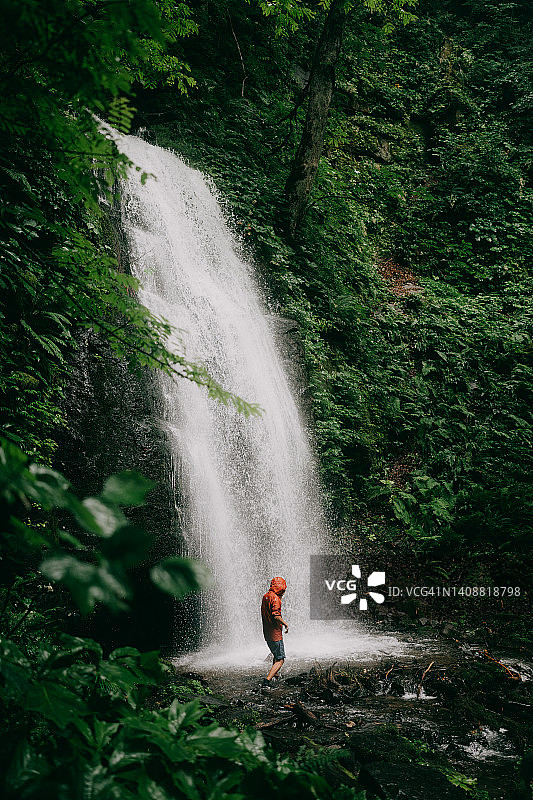 男人在森林瀑布前行走图片素材