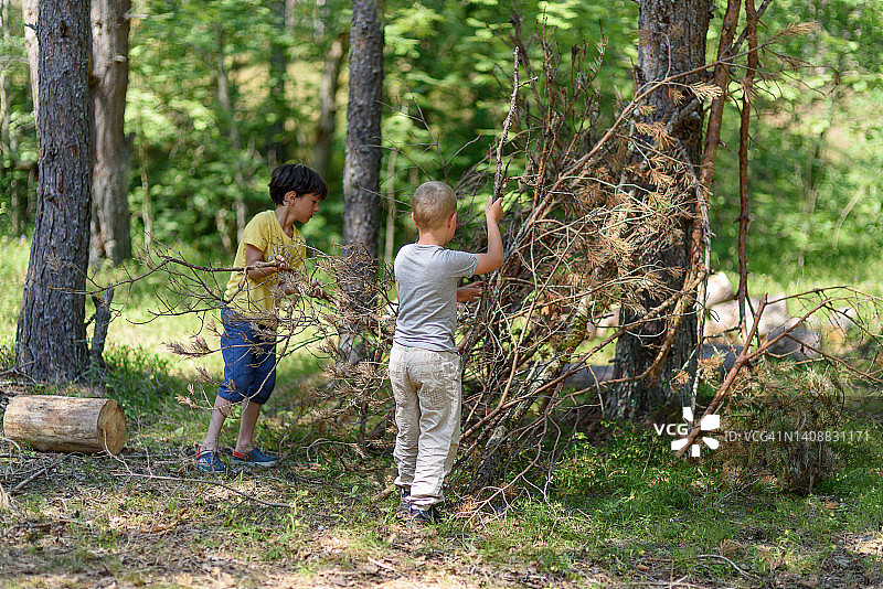 两个男孩在森林里建造房子图片素材