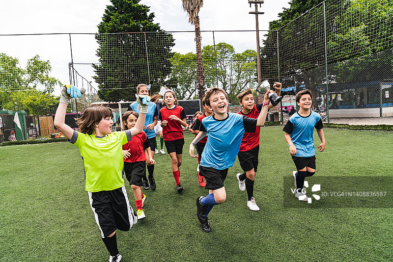 孩子们在足球场上庆祝比赛胜利图片素材
