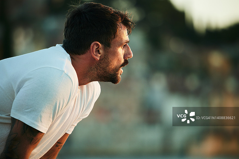 年轻的男运动员在运动训练中休息图片素材