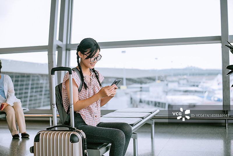 女孩在机场候机室使用手机图片素材