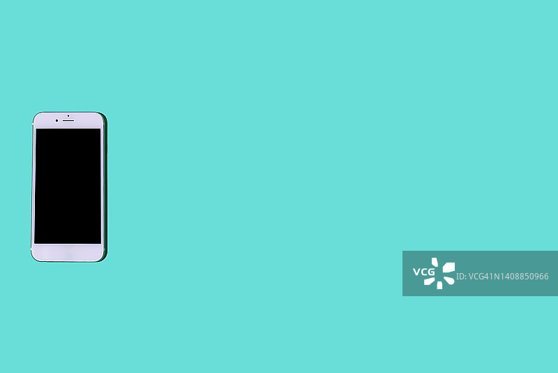 位于蓝绿色背景左侧的白色手机。智能手机、手机、短信、消息、娱乐、通话、对话、互联网、连接概念图片素材