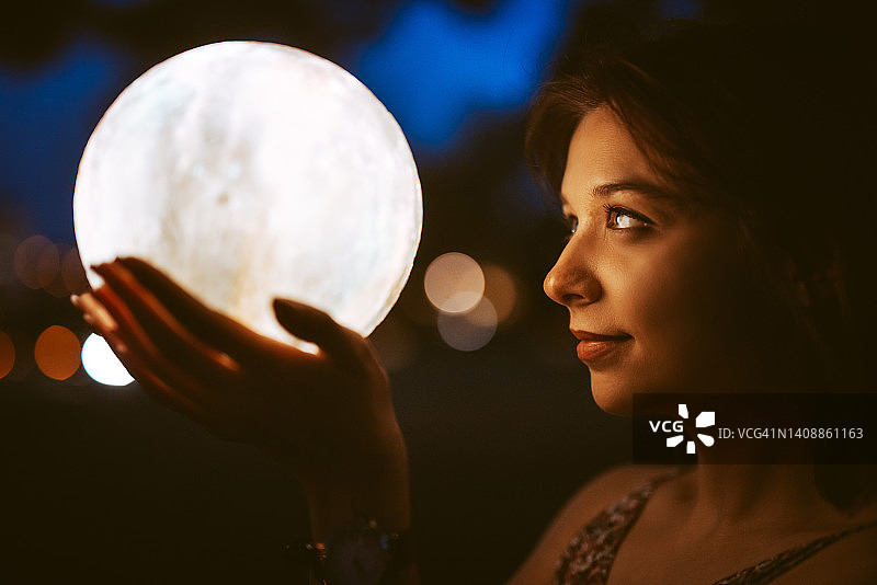 手持月光灯的年轻女人图片素材