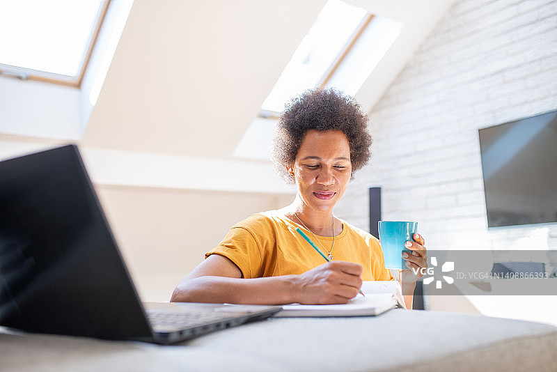 穿着时尚的中年妇女在家工作图片素材