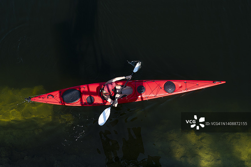 年轻女子划红色皮划艇图片素材