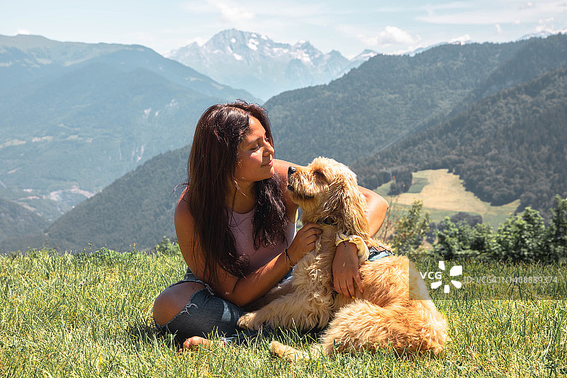 在法国阿尔卑斯山与获救的狗狗一起旅行的拉丁裔女人图片素材