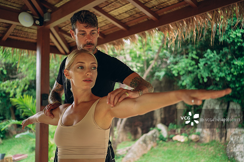 女人在教练的指导下练习瑜伽图片素材