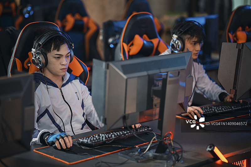 电竞总决赛：亚裔电竞选手专注玩RPG第一人称射击游戏图片素材