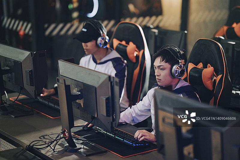 电竞总决赛：亚裔电竞选手专注玩RPG第一人称射击游戏图片素材