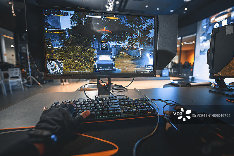 电竞总决赛现场，亚洲电竞选手第一人称视角与队友一同参与射击游戏直播对抗其他队伍图片素材