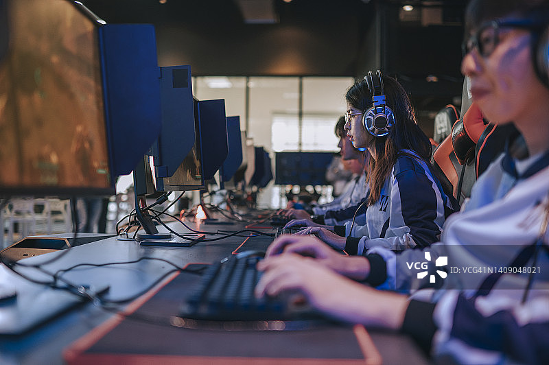 亚洲女电竞团队选手专注玩RPG第一人称射击游戏图片素材