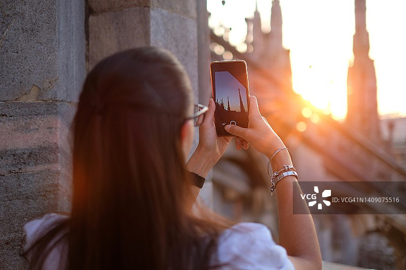 女孩在小镇拍摄日落，背影图片素材