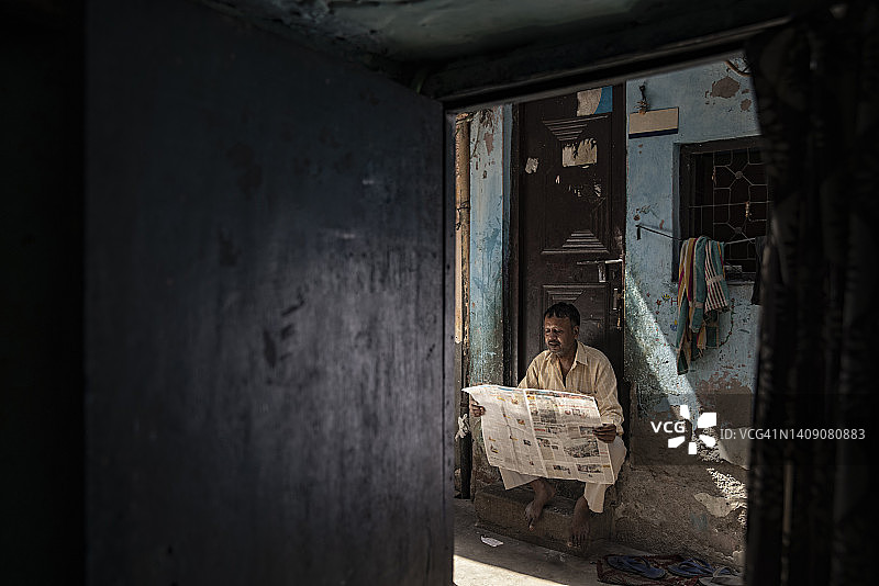 中年男人在门口读报纸图片素材