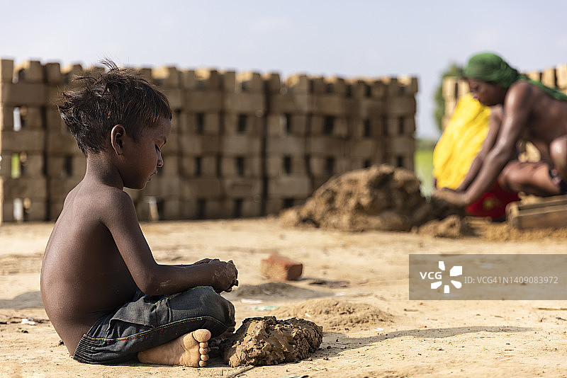 坐在砖厂里的男孩的侧面图片素材