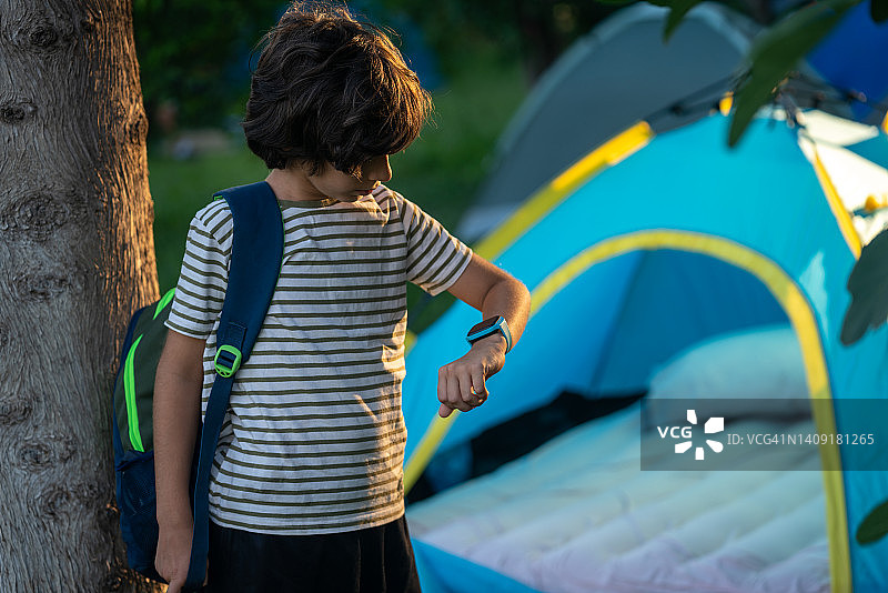 小学生在露营时使用智能手表图片素材