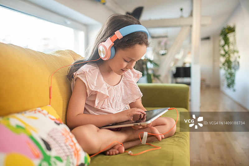 玩平板电脑玩得很开心的小女孩图片素材