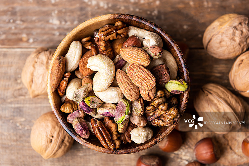 黑石桌上的木碗坚果：腰果榛子核桃杏仁俯视图图片素材