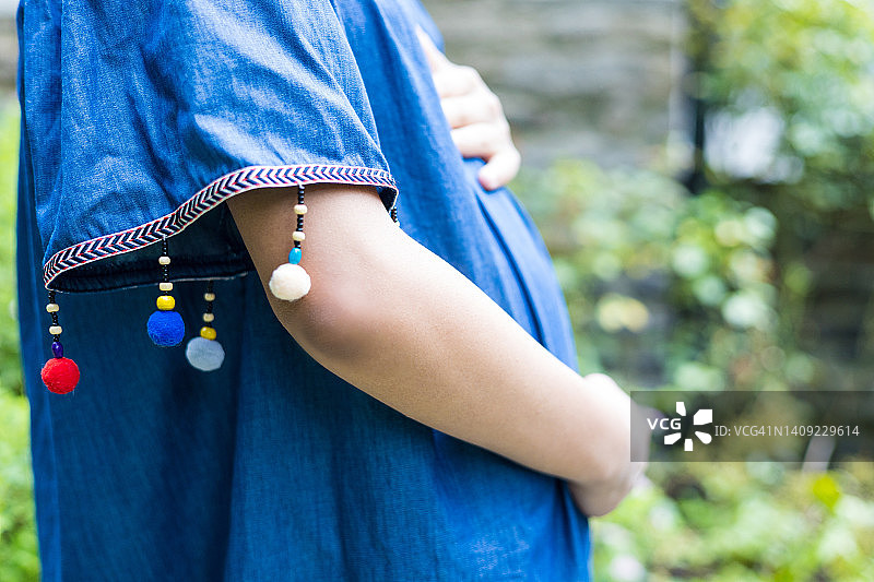 在户外托着隆起腹部的混血孕妇图片素材