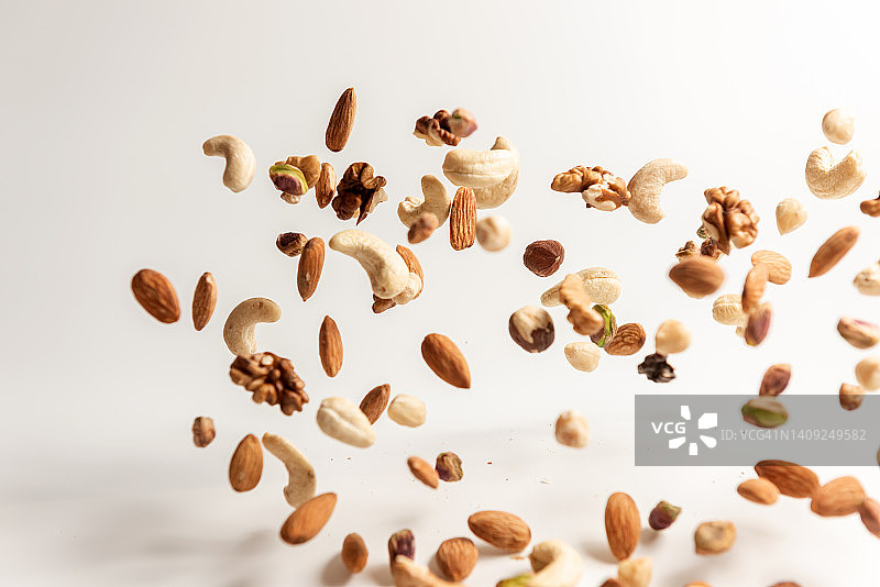 掉落的各种坚果：核桃、杏仁、榛子、开心果、腰果图片素材