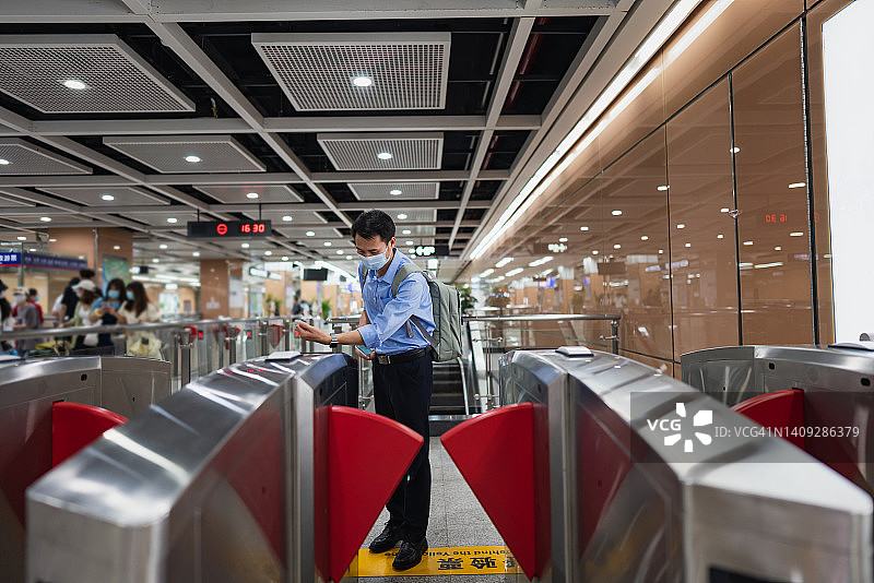 地铁站出口，一男子使用智能手表进行非接触式支付图片素材