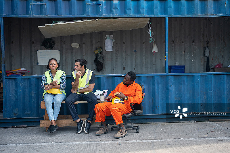 三名多种族码头工人休息时享受午餐图片素材